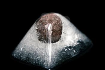 stone in the ice cube on a black background