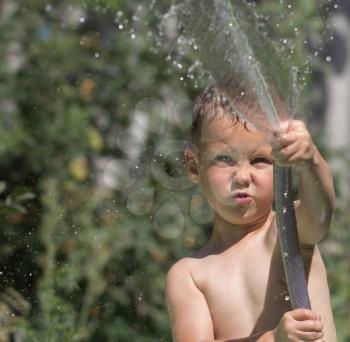 boy squirting water from a hose
