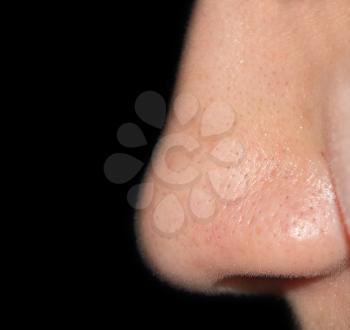 Women's nose on a black background close-up