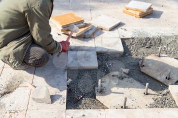 Worker puts sidewalk tile