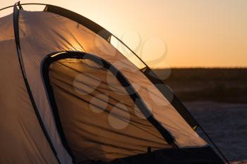 Tent of a traveler at sunset as a background