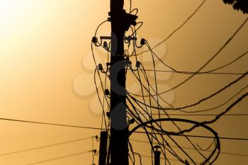 electric pole with wires on the golden sunset .