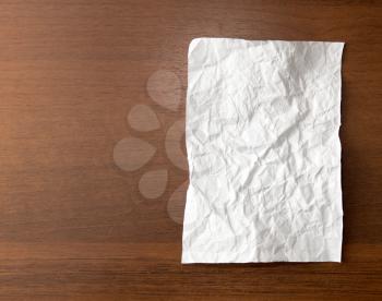 crumpled white paper on the wooden background