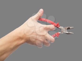 pliers in hand on gray background