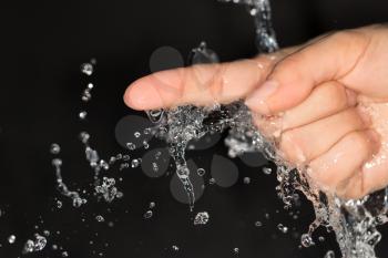 Hand in water on a black background