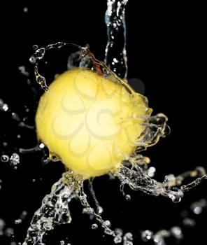 yellow apple in water on a black background