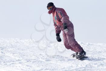 Jumping snowboarder from hill in winter