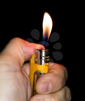 a flame of fire from the cigarette lighter on a black background