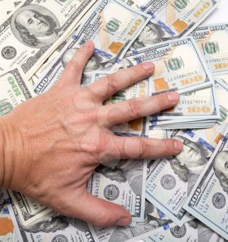 hand on a pile of dollars