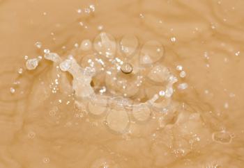 Drops of water falling into the dirty water