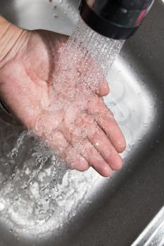 hand in the water in the sink