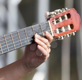 girl's hand playing guitar