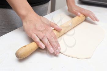 rolling the dough in the kitchen