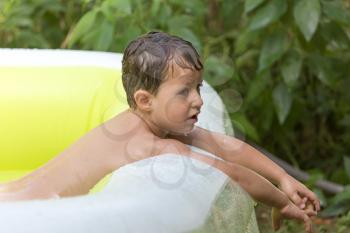 boy pours water from the pool in nature