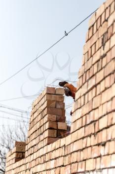 Worker builds a brick wall in the house .