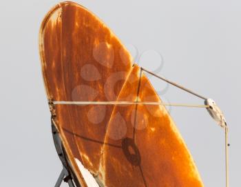 Old rusty satellite dish on the roof at sunset