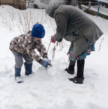 a boy with his grandmother playing in the snow .