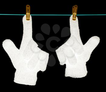 The glove is dried on a rope on a black background .
