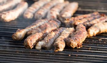 Sausages are fried on a large barbecue