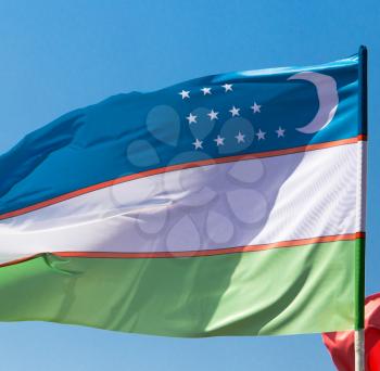 flag of Uzbekistan against the blue sky .