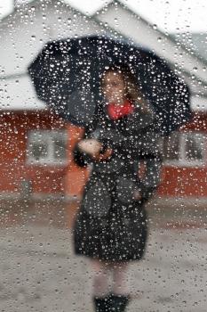 Royalty Free Photo of a Woman Holding an Umbrella in the Rain