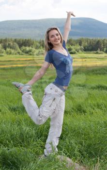 Royalty Free Photo of a Girl Stretching in a Field