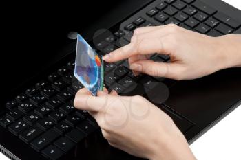 Royalty Free Photo of a Woman Holding a Bank Card by a Laptop