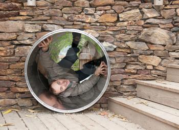 Royalty Free Photo of a Man Hiding in a Pipe