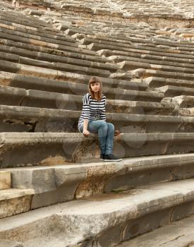 Royalty Free Photo of a Girl Sitting at Amphitheater Ruins in Turkey