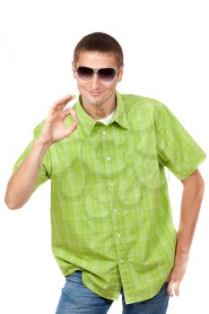 Smiling young man with sunglasses wearing checkered shirt shows Ok symbol. Isolated on white background, mask included