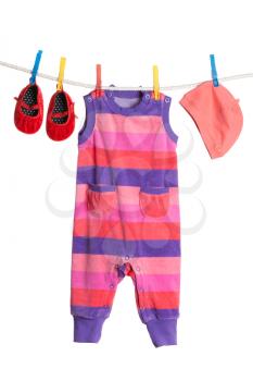 A set of children's clothes hanging on a clothesline. Isolate on white.