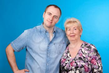 portrait of mother and son in a studio on blue background