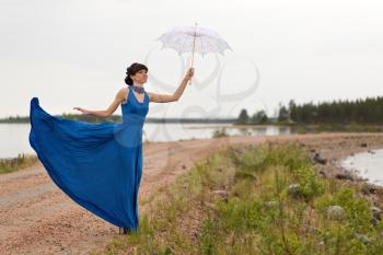 girl tries to keep a umbrella which pulls out a wind from her hands.