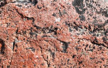 background of red granite stone in daylight