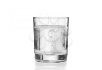 Glass with efervescent tablet in water. Isolated on white.