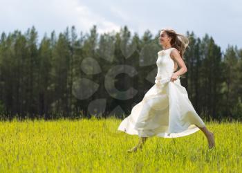 girl in white dress jumping in a field