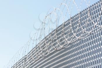 Royalty Free Photo of Barbwire Above a Fence