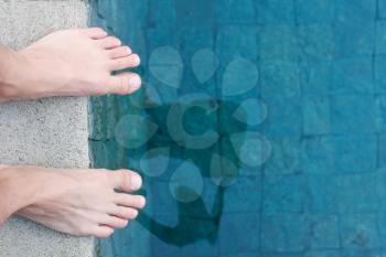 Royalty Free Photo of a Person Standing by a Swimming Pool