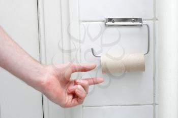 Royalty Free Photo of a Person Reaching for Toilet Paper