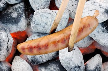 Royalty Free Photo of a Sausage Being Barbecued