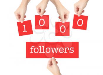 1000 followers written on cards held by hands