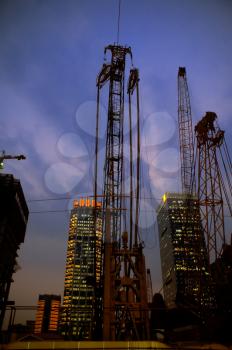 construction cranes on night ove a blue sky