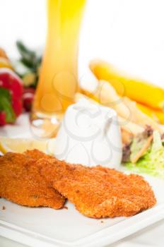 classic breaded Milanese veal cutlets with french fries , vegetables and glass of lager beer on background ,MORE DELICIOUS FOOD ON PORTFOLIO