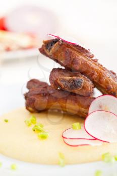 traditional Italian roasted pork ribbs served on polenta bed,corn cream