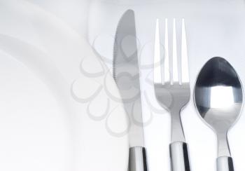 close up of a cutlery set on a table with napkin and dish