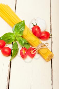  raw ingredients spaghetti pasta tomato and basil foundations of Italian cuisine