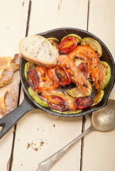 roasted shrimps on cast iron skillet  with zucchini and tomatoes