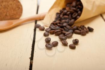 espresso coffee beans on a paper cone cornucopia over white background
