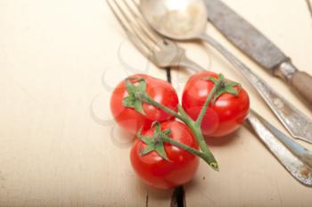 ripe cherry tomatoes cluster over white rustic wood table