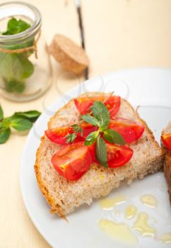 Italian tomato bruschetta with thyme and mint leaves 